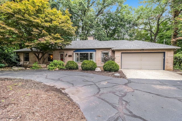 485 E Hamilton Ln, Michigan, MI 49015 - view of front of home with driveway, brick siding, a garage, and a chimney