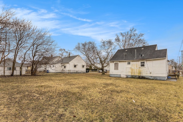 back of property with fence and a lawn