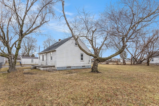 view of home's exterior featuring a lawn and fence