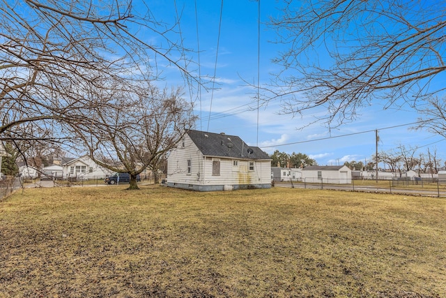 rear view of property with crawl space, fence, and a lawn