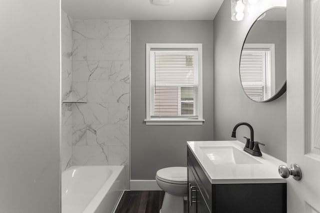 bathroom featuring shower / bathing tub combination, toilet, vanity, wood finished floors, and baseboards