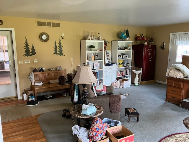 living room featuring baseboards, visible vents, and wood finished floors