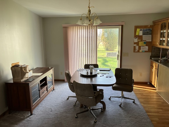 dining room with baseboards, a notable chandelier, and wood finished floors