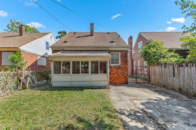 rear view of house featuring brick siding, a yard, a patio, a shingled roof, and a fenced backyard