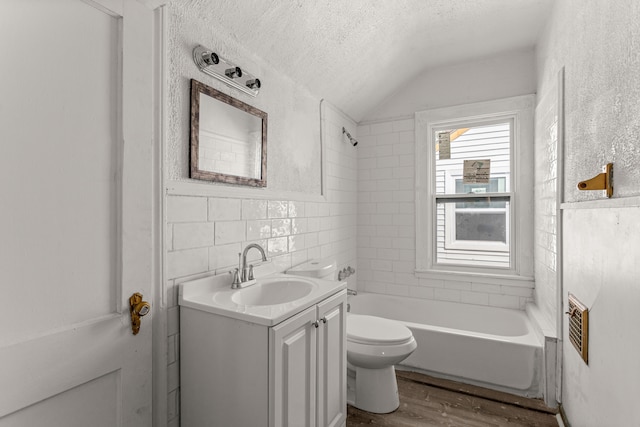 bathroom with tile walls, toilet, vanity, a textured ceiling, and wood finished floors