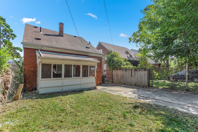 view of front of home featuring brick siding, a shingled roof, a chimney, fence, and a front yard