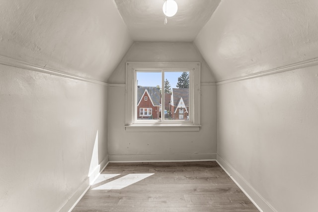 bonus room featuring vaulted ceiling, baseboards, and wood finished floors