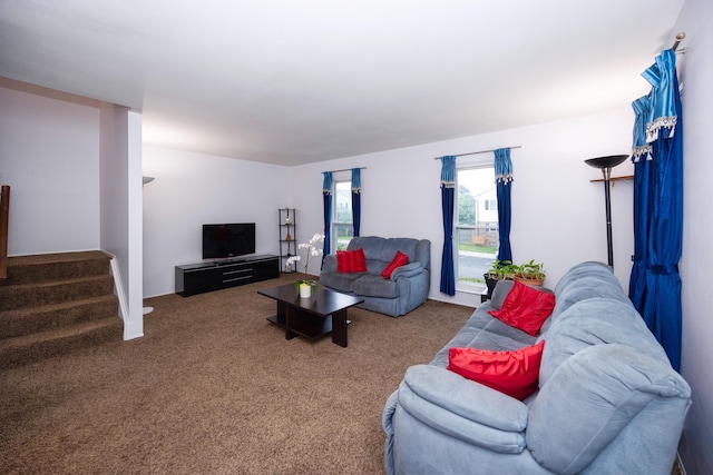 carpeted living room featuring stairs