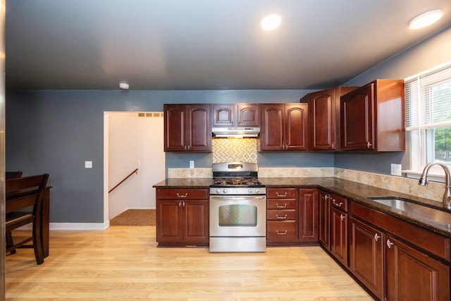 kitchen featuring a sink, under cabinet range hood, light wood-style flooring, and stainless steel range with gas stovetop