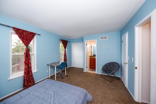 bedroom featuring ensuite bathroom, carpet floors, visible vents, and baseboards