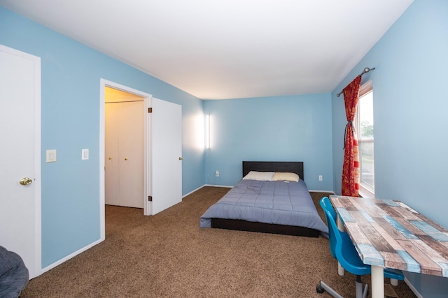 bedroom featuring dark carpet and baseboards