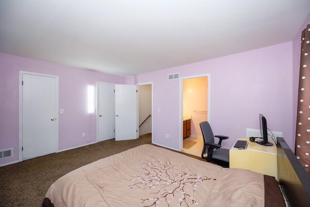 carpeted bedroom with visible vents and ensuite bathroom