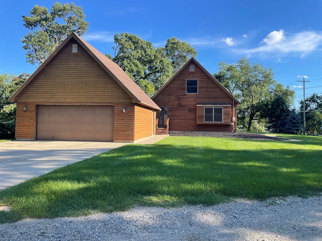 view of front of property with a front yard, a detached garage, and an outdoor structure