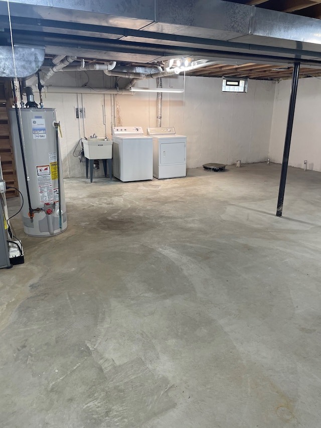 basement with a sink, washer and dryer, and gas water heater