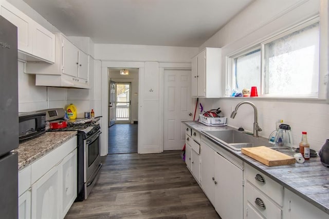 kitchen featuring dark wood-style flooring, white cabinetry, light countertops, appliances with stainless steel finishes, and tasteful backsplash