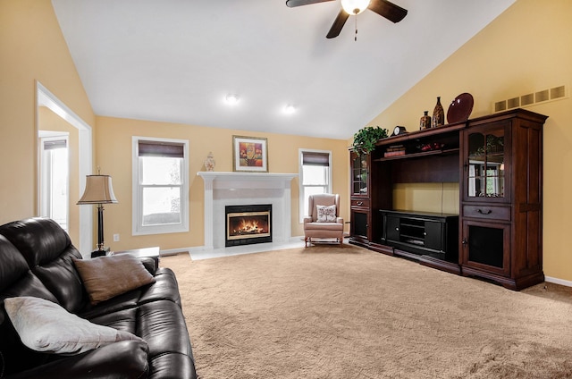 living room featuring lofted ceiling, carpet, visible vents, and a lit fireplace