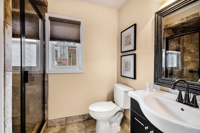 bathroom with a stall shower, vanity, toilet, and tile patterned floors