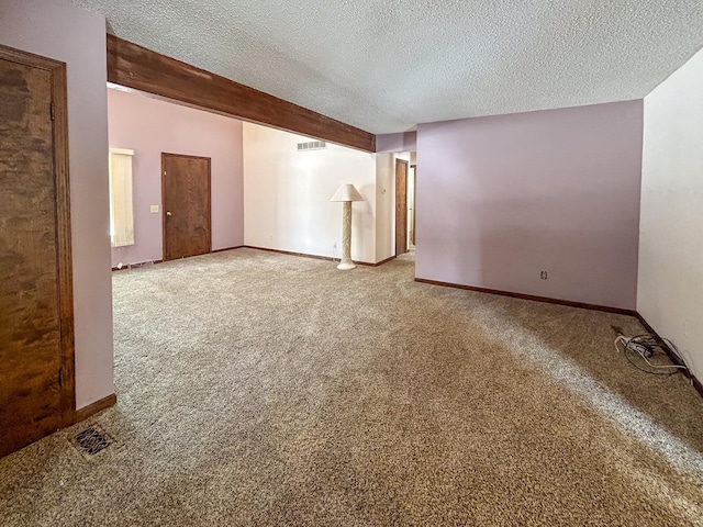 empty room featuring a textured ceiling, visible vents, baseboards, beam ceiling, and carpet