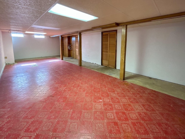 below grade area featuring a paneled ceiling and tile patterned floors