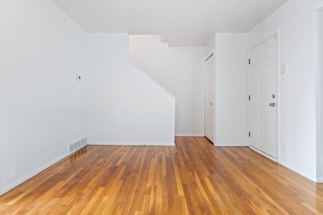 interior space with baseboards, visible vents, and wood finished floors