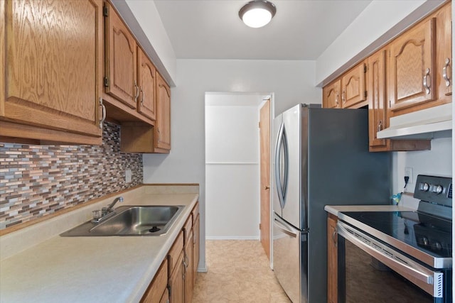 kitchen featuring backsplash, stainless steel appliances, light countertops, under cabinet range hood, and a sink