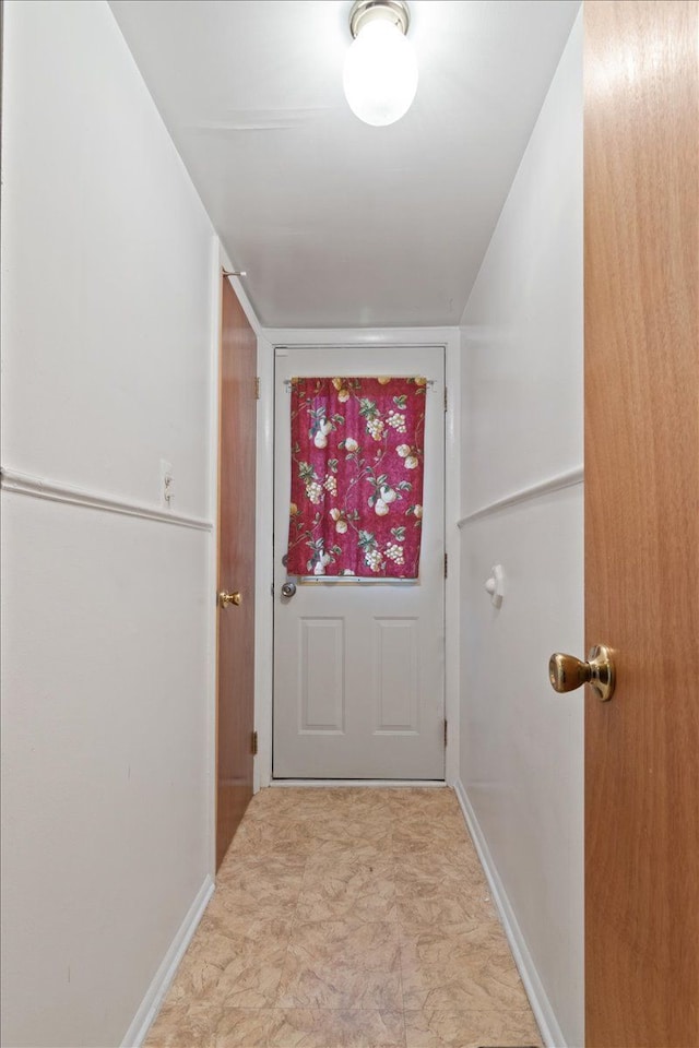 doorway to outside featuring baseboards