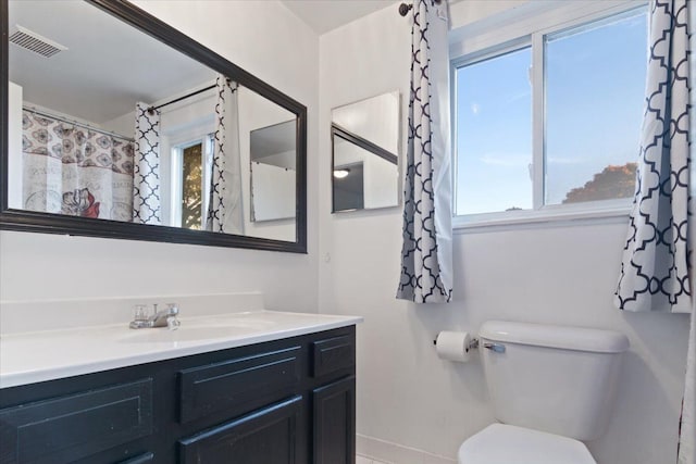 bathroom featuring toilet, baseboards, visible vents, and vanity