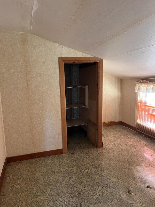 empty room with lofted ceiling and baseboards