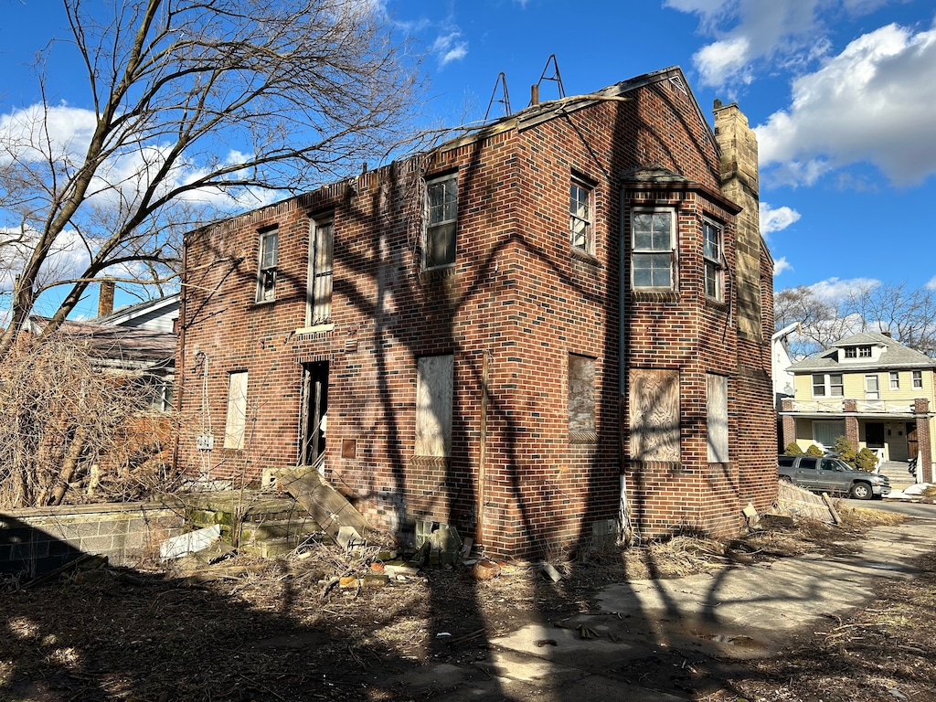 view of home's exterior with brick siding and a chimney