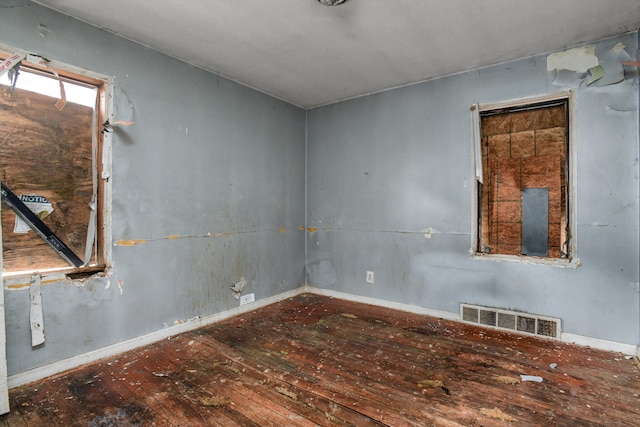 empty room featuring visible vents and wood-type flooring