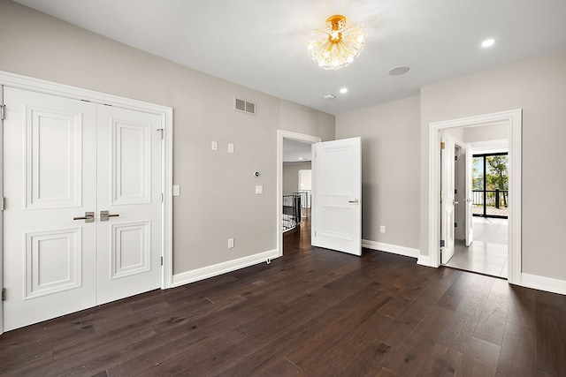 unfurnished bedroom with dark wood-style floors, recessed lighting, a closet, visible vents, and baseboards