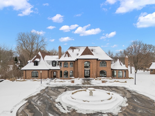 view of front of home with brick siding and a chimney