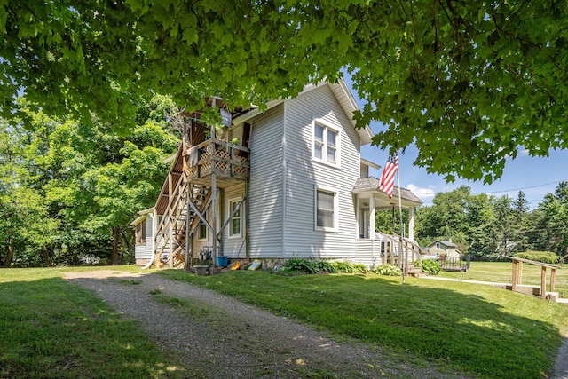 view of home's exterior featuring stairway, cooling unit, and a yard