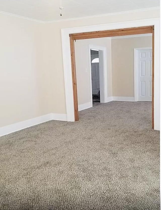 empty room with ornamental molding and baseboards