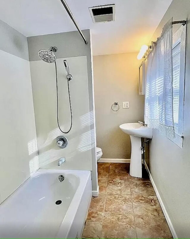 full bathroom with baseboards, visible vents, toilet, washtub / shower combination, and a sink