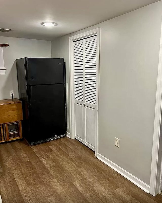 kitchen featuring freestanding refrigerator, dark wood-style flooring, visible vents, and baseboards