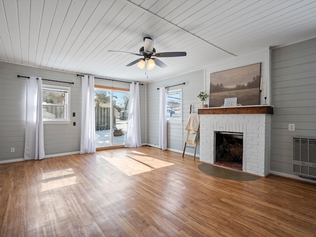 unfurnished living room with a fireplace, ceiling fan, wood finished floors, wooden ceiling, and baseboards