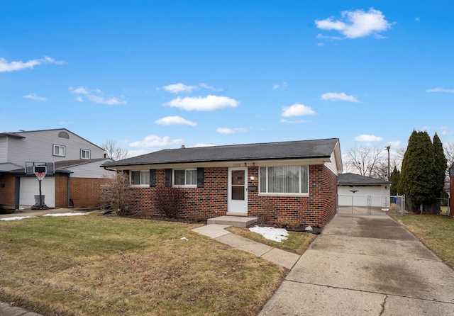 view of front of house featuring a shingled roof, a gate, fence, a front yard, and brick siding