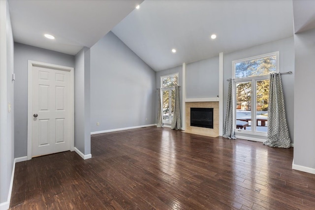 unfurnished living room with dark wood-style flooring, recessed lighting, a fireplace with flush hearth, and baseboards