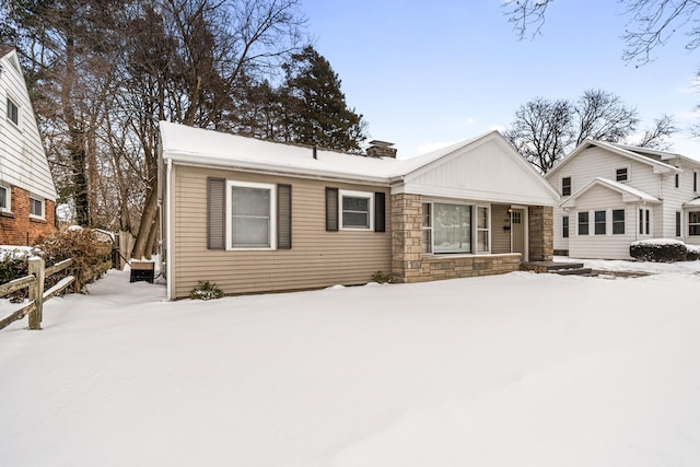 view of front of home with stone siding and a chimney