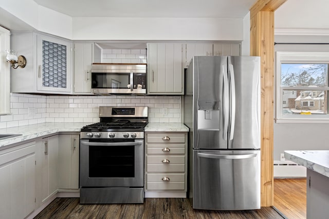 kitchen featuring gray cabinets, appliances with stainless steel finishes, dark wood finished floors, and backsplash