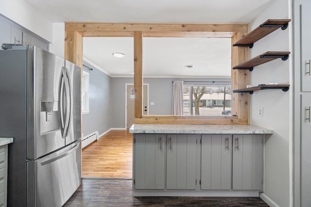 kitchen featuring stainless steel refrigerator with ice dispenser, open shelves, gray cabinets, light countertops, and baseboard heating