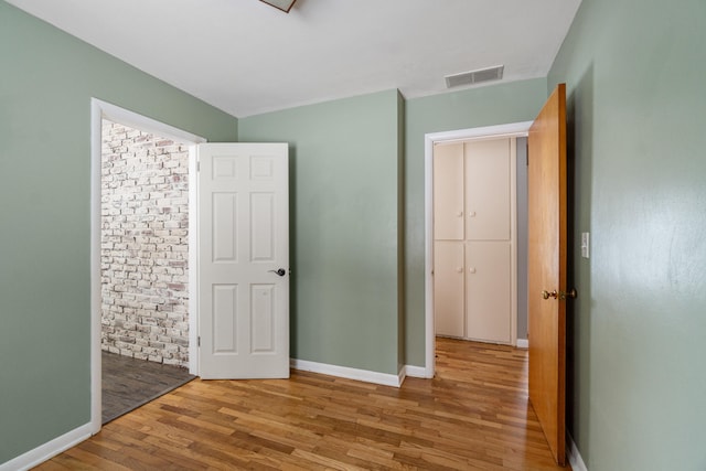 interior space featuring light wood-type flooring, visible vents, and baseboards