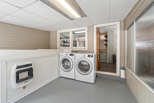 washroom with laundry area, baseboards, washer and clothes dryer, and heating unit