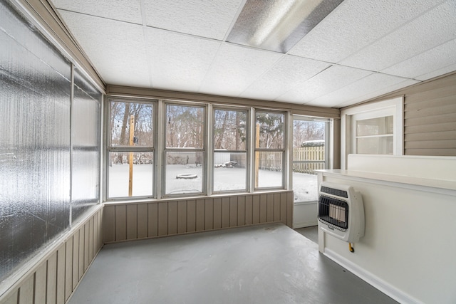 unfurnished sunroom featuring a drop ceiling and heating unit