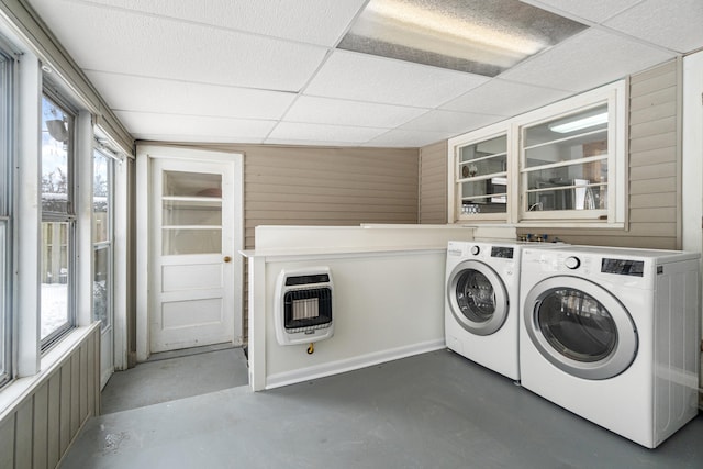 clothes washing area featuring wooden walls, laundry area, heating unit, and washer and dryer