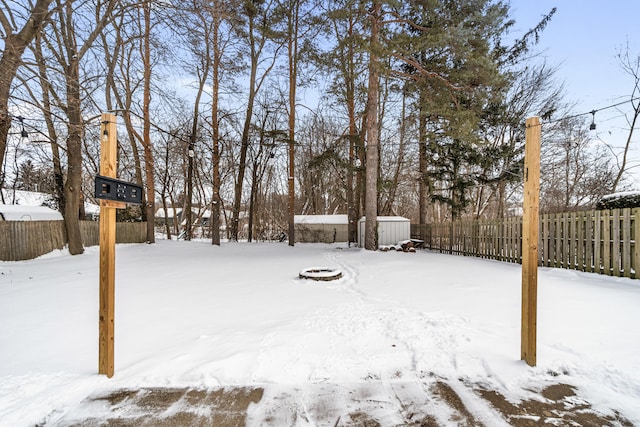 yard covered in snow featuring fence