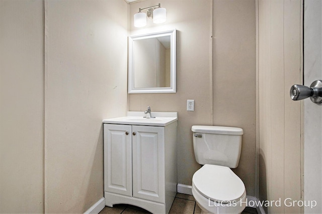 bathroom with toilet, tile patterned floors, vanity, and baseboards