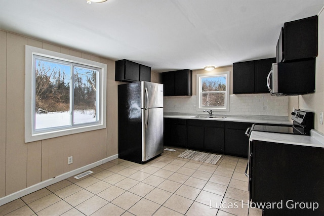 kitchen featuring visible vents, dark cabinetry, stainless steel appliances, and light countertops