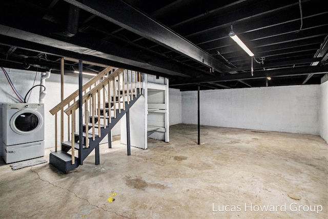 unfinished basement featuring stairs and washer / clothes dryer